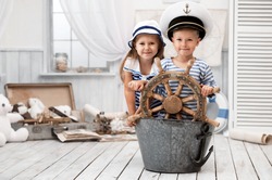 Boy and girl dressed as a captain and sailors played on the ship out of the bath in his room