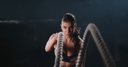 Copy space. fitness athletes training using battle ropes intense workout team exercise challenge in gym friends enjoying healthy bodybuilding endurance practice lifestyle.