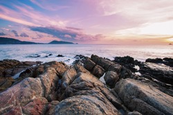 Long exposure image of Dramatic sky seascape with rock in sunset scenery background
