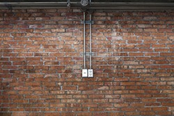 Steel pipe electric wire and plug on vintage brick wall background
