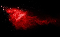 Freeze motion of red powder exploding, isolated on black, dark background. Abstract design of red dust cloud. Particles explosion screen saver, wallpaper