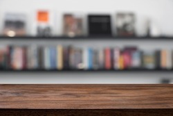 Empty wood table with blurred background of library or bookstore. For present product.