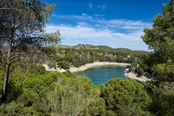 Spectacular panoramic views of the Guadalhorce reservoir, next to the Caminito del Rey in Malaga, Andalusia, Spain. Turquoise blue water and forest with blue sky on a sunny day.