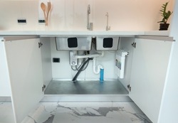 Open cabinet under sink 2 bowls with installed water pipe, water filter , Accessories aluminium under cabinet sink protection .White kitchen cabinet.