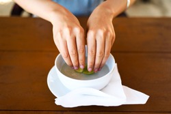 Woman washing hands in lime water in a restaurant