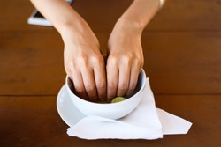 Woman washing hands in lime water in a restaurant