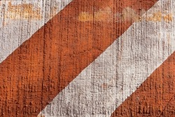 Traffic signage. Orange and white slanted stripes of paint on rustic wood.