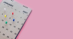 Calendar and appointment scheduler with a pin on a pink background.
