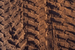 Brown sand with tire tracks from the wheel loader