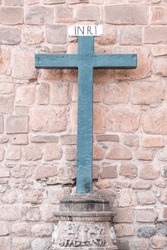 Inri christian cross symbol behind of catedral wall in Cusco Peru. Selective focus. 