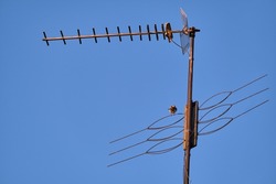 Antenna on a blue sky background . Metal radio antenna close - up .