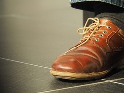 Detail of a men footwear formal leather dress shoes worn on a leg with copy space. (RGB unedited)