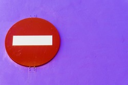 Forbidden direction sign on purple wall.