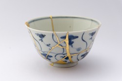 Kintsugi blue and white decorated tea ceremony chawan bowl. Gold cracks restoration on old Japanese pottery restored with the antique Kintsugi restoration technique. The beauty of imperfections. 