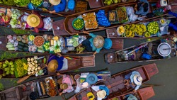 Aerial view famous floating market in Thailand, Damnoen Saduak floating market, Farmer go to sell organic products, fruits, vegetables and Thai cuisine, Tourists visiting by boat, Ratchaburi, Thailand