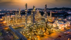 Oil refinery plant from industry zone, Aerial view oil and gas petrochemical industrial, Refinery factory oil storage tank and pipeline steel at night, Ecosystem and healthy environment.