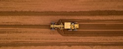 Aerial view yellow excavator building a highway, Road grader heavy earth moving, Bulldozer working at road construction.