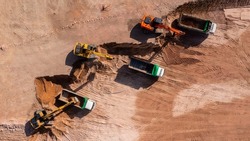 Construction site, Aerial top view road roller and loader excavator tractor and soil grade car earthmoving at work, Heavy equipment is grading the land, moving and flattening out red clay soil.
