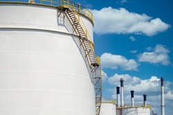 White oil storage tanks at petrol industrial zone, Industrial oil tanks in a refinery, White fuel storage tank against blue sky.