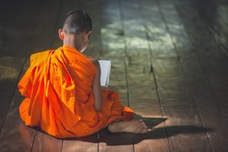 Young Buddhist novice monk reading, Young Buddhist novice monk study inside monastery, Thailand
