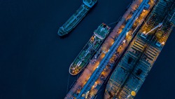 Aerial view oil and gas tanker cargo ship offshore at the port at night, Industry refinery fuel chemical import export business logistic and transportation.
