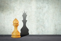 White pawn with the shadow of the queen. Motivation concept. Strength and aspirations. Confidence in your strength. Business. Lifestyle. Abstract background. Background.