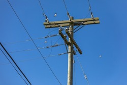 Wooden power utility pole and clear blue sky. Electric pole power lines and wires on the blue sky Background. Nobody, copy space for text, selective focus, concept photo electric technology.