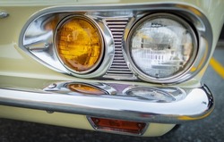 Vintage Car Front Detail. Classic car headlights close-up. Headlights of yellow vintage car. Exhibition. Nobody, street photo, selective focus, blurred