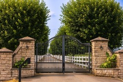 Iron front gate of a beautiful luxury home. Fancy large mansion behind a locked gate. Nobody, street photo, selective focus
