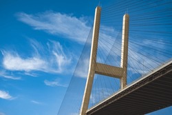 Modern bridge pylon against a blue sky. Detail of the multi-span cable-stayed bridge. Linear perspective view of a cable-stayed suspension Alex Fraser Bridge in BC. Nobody, selective focus