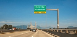 The Golden Ears Bridge, connecting Maple Ridge to Langley. Traffic on a cable-suspended bridge spanning across Fraser River on a sunny summer day. Vancouver British Columbia Canada