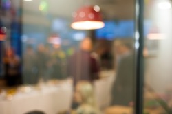 People celebrating dining in cafe through window glass background bokeh