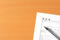 A blank resume and a pen on the desk. On the resume form, the items to be filled in each column such as name, ruby, date of birth,  etc. are shown in Japanese.