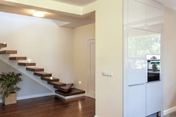 Bright space - wooden stairs and a wall with an oven