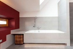 White bath in modern bathroom with red wall