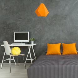 Modern decor of teenager's bedroom with big double grey bed. On the top of bed two orange pillows