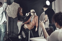 Fashion stylist with professional model at photoshoot backstage