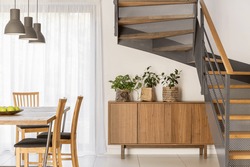 Dining room situated beside industrial wooden and metal staircase 