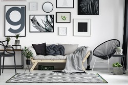Wooden sofa with dark pillows in scandi style living room