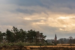 February heath landscape with a view on the medieval Jacobus church of Rolde - Balloërveld, Drenthe, Netherlands.