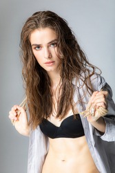 Fashion portrait of a girl with wet hair with a rope in her hands
