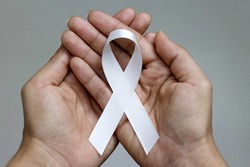 White January, mental health awareness campaign. Person holding a white ribbon.