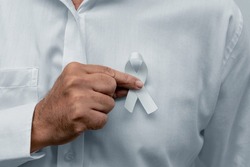 White January, mental health awareness campaign. Man holding a white ribbon.