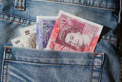 Great Britain pound banknotes in back pocket of blue jeans