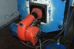 Old gas-oil burner in a boiler room 