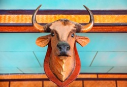 fishing village of thailand - wooden bull head, decoration for thai interior, on a blue background with bright orange stripes