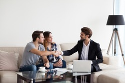 Young couple, family at meeting with realtor, interior designer, decorator, landlord making deal. Husband handshaking with man in suit. Concept of meeting with client, customer