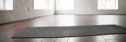 Horizontal image personal yoga pilates rubber mat carpet on wooden floor at modern room of sport center no people. Healthy active lifestyle concept, panoramic photo banner for website header design
