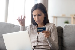 Upset young woman using online banking service, problem with blocked credit card, using laptop, irritated girl checking balance, internet fraud concept, bankruptcy or debt, overspend