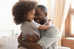 Sweet moments of fatherhood concept, happy african father hold embrace cute little child daughter, smiling black family mixed race daddy and small kid hugging cuddling enjoying time together at home